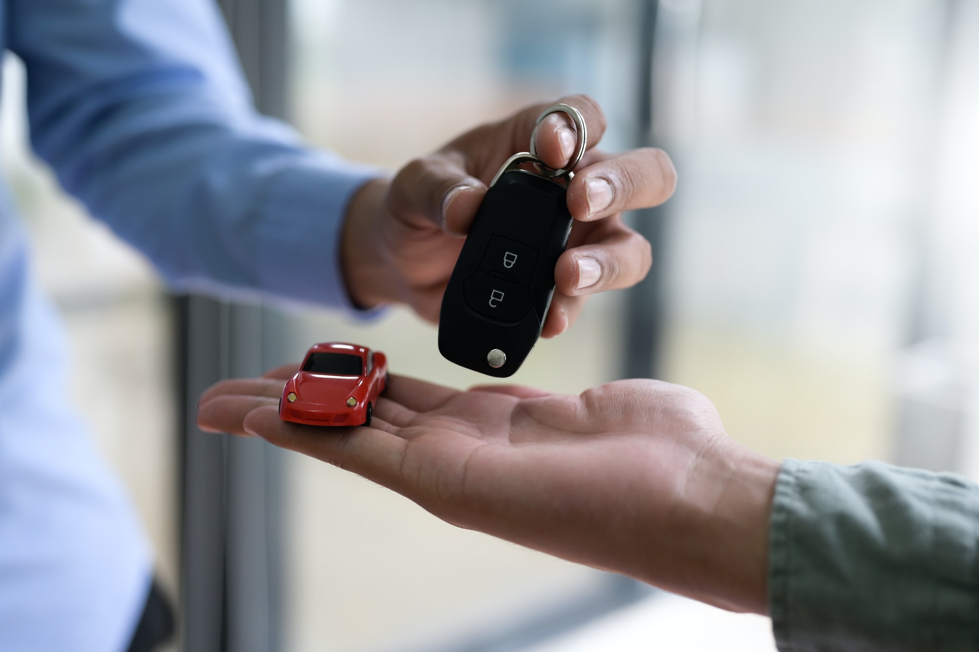 Close-up shot of exchanging car keys and model cars, Finance concept, Insurance, Car seizure.