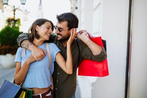 Beautiful young loving couple walking by the street while shopping and traveling