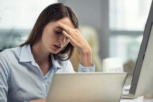 Woman With Headache Working In Office