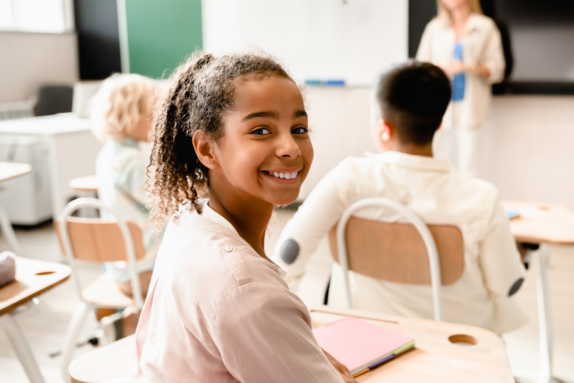 African-american young smart schoolgirl pupil attending school lesson class listening to teacher