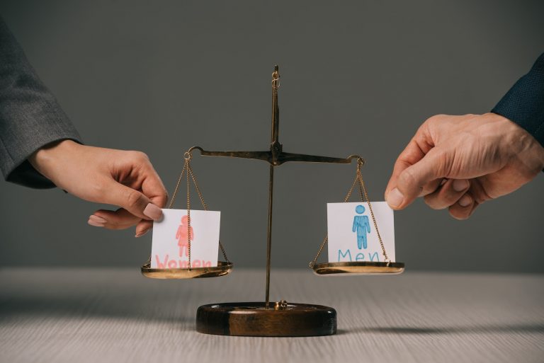 cropped view of businesspeople with male and female signs on scales of justice, gender equality